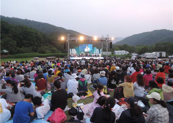 칠곡군 동명면 한티순교성지 잔디광장에서 수많은 관람객이 잔디밭 돗자리에 앉아 콘서트 무대를 관람하고 있다.(자료사진)/칠곡군
