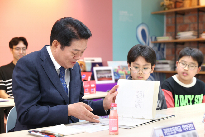 (사진2) 최대호 안양시장이 귀인초등학교 어린이들이 직접 쓴 교통 감사 엽서를 읽어 보고 있다