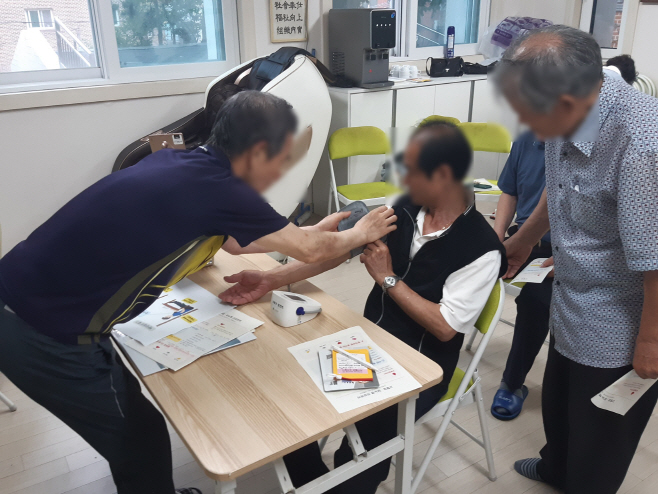 260723 (사진1) 건강경로당에서 어르신이 올바른 혈압 측정법을 실습하고 있다.