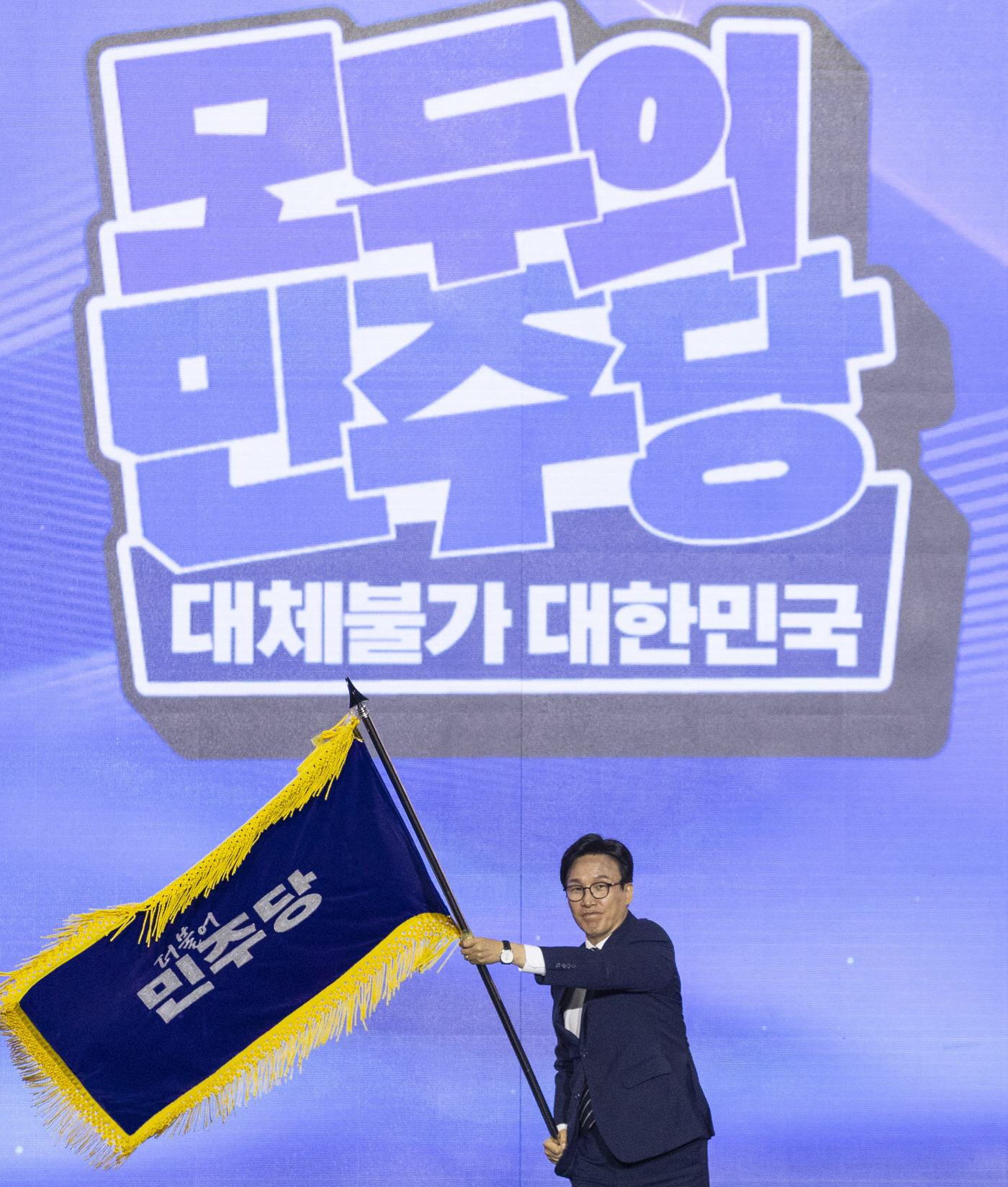 당 깃발 흔드는 신임 민주당 김민석 대표<YONHAP NO-5361>