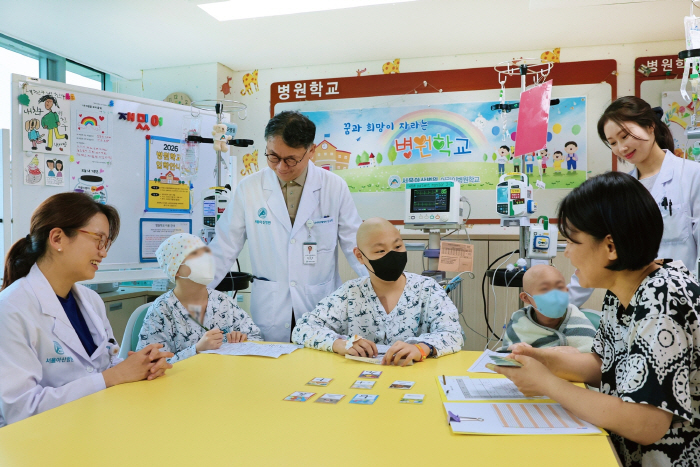[사진] 서울아산병원 어린이병원학교에서 김혜리 어린이병원학교장, 임호준 어린이병원장이 자원봉사자 이은정 교사에게 한문수업을 듣고있는 소아암 환아들을 격려하고 있는 모습