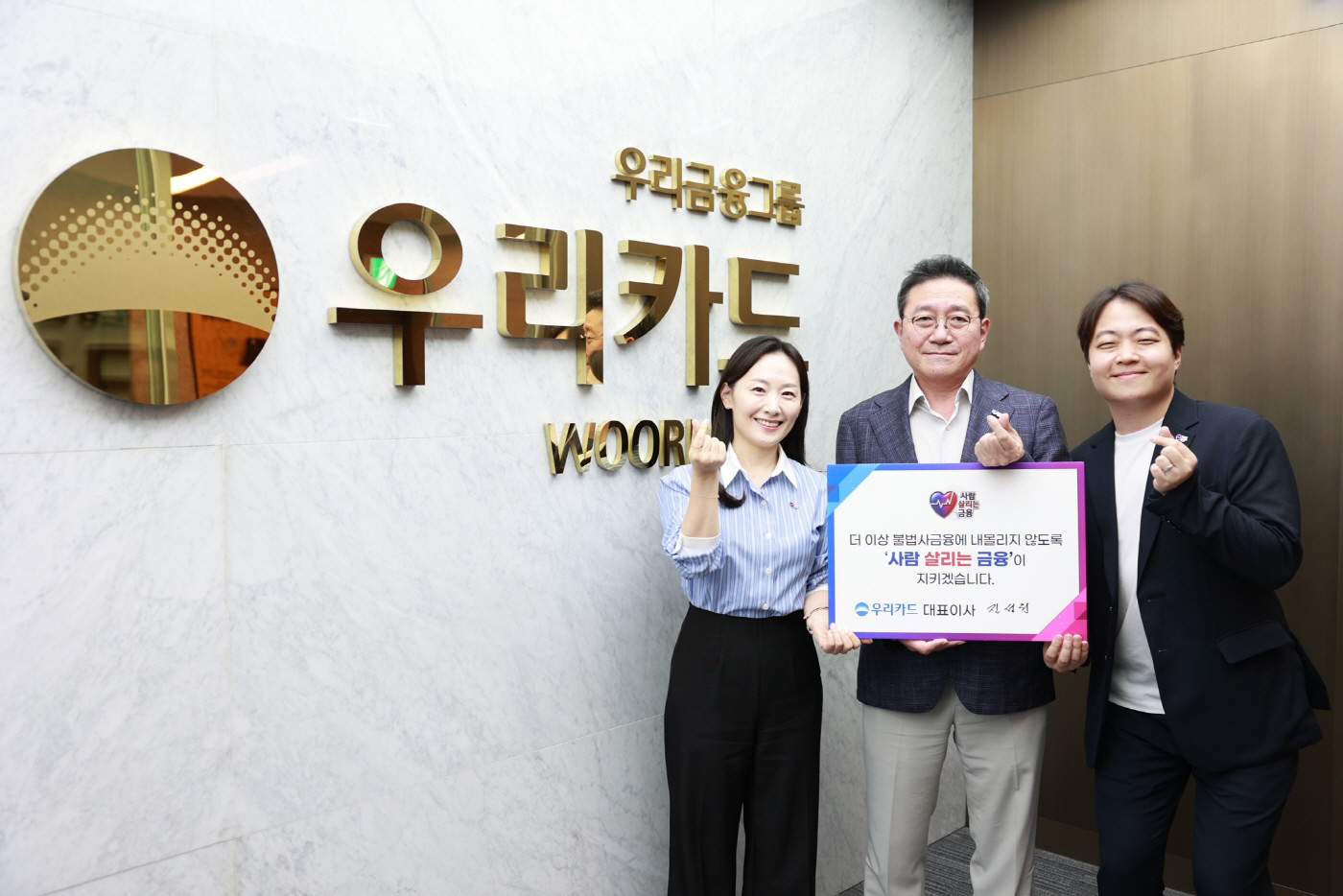 (사진설명) 이달 7일 우리카드 광화문 본사에서 진성원 우리카드 사장(가운데)이 사람 살리는 금융 캠페인에 참여해 기념 사진을 찍고 있다.