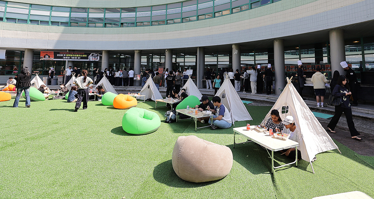 인제대학교 늘빛관 앞마당에 조성된 야외 피크닉 존에서 학생들이 BBQ와 음료를 즐기며 가을 캠퍼스 분위기를 만끽하고 있다.