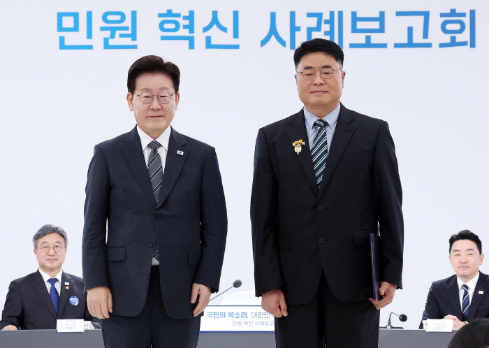 사본 - 1. 이재명 대통령이 2일 세종특별자치시에서 열린 ‘국민의 목소리, 대한민국을 바꾼다’ 민원 혁신 사례보고회에서 김정환 경기 화성시 주차시설팀장에게 대통령 표창을 수여하고 기념촬영을 하고 있다