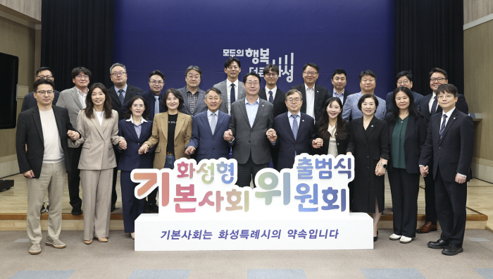 1-2. 정명근 화성특례시장, 조승문 화성특례시 부시장이 화성형 기본사회위원회 위원들과 손을 맞잡고 기념촬영을 하고 있다
