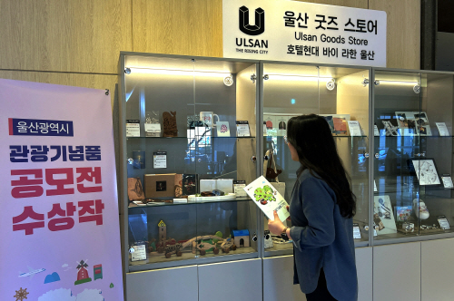 사진1_호텔현대 바이 라한 울산 1층에 마련된 ‘울산 굿즈 스토어’ 테마 매대에서 투숙객이 울산 관광기념품을 둘러보고 있다.